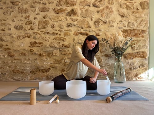 Femme pratiquant la méditation sonore avec des bols de cristal au Domaine Du Commandeur, Mondragon