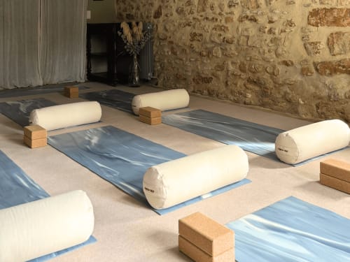 Studio de yoga du Domaine Du Commandeur à Mondragon avec tapis roulés et blocs de liège sur des tapis bleus