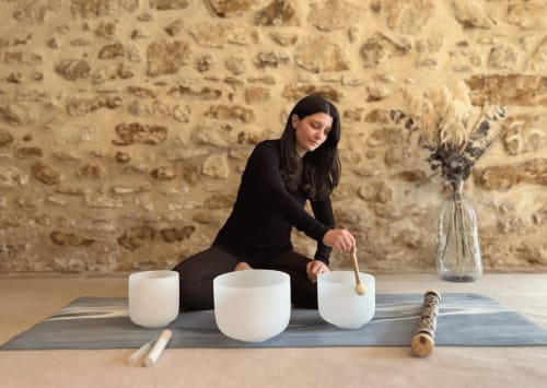 Femme jouant des bols chantants à la boutique et gîte Domaine Du Commandeur à Mondragon, France