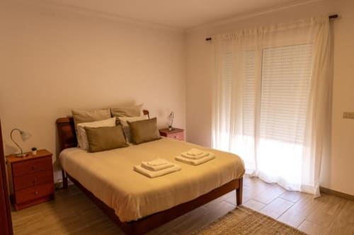 Quarto espaçoso na Gomes Equestre Alojamento em Golegã com cama queen, móveis em madeira e portas de vidro com vista para a natureza