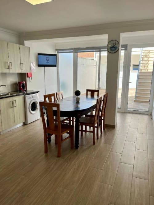 Cozinha-sala de jantar moderna em Gomes Equestre Alojamento em Golegã com mesa de madeira, cadeiras e eletrodomésticos contemporâneos