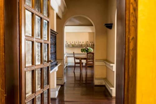 Elegante corridoio di Villa Dom a Piacenza con arcata, dettagli in legno e arredi raffinati