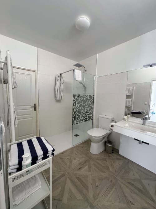 Salle de bain moderne du Studio Montségur à Domaine de Bize, avec douche à l'italienne, toilettes, lavabo et sèche-serviettes chauffant