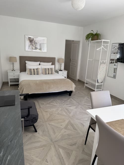 Chambre Studio Montségur au Domaine de Bize avec lit, tables de nuit blanches, armoire et coin repas au BnB de Mirepoix