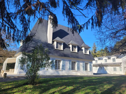 Élégante maison de maître blanche aux volets bleus et toit sombre à Mirepoix, Ariège, avec jardins soignés et cyprès