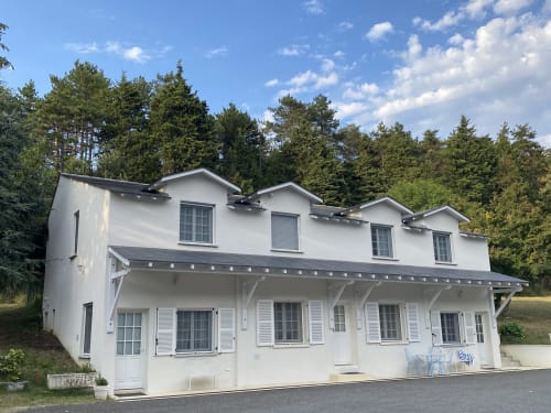 Appartement studio blanc et moderne au Domaine de Bize à Mirepoix avec vue sur le jardin, terrasse couverte et forêt en arrière-plan