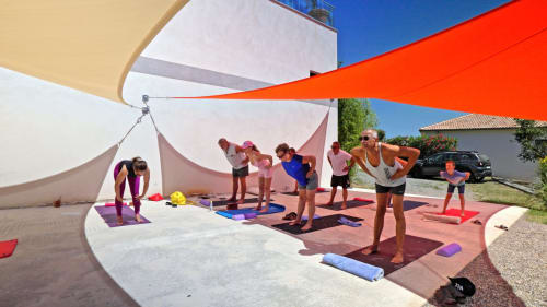 Outdoor yoga class under colorful shade sails at Corse et Zen hotel in Corsica