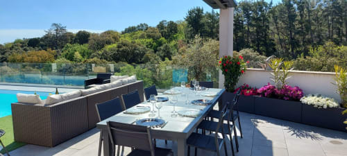Corse et Zen rooftop terrace with pool view, dining table, and flowering planters overlooking Taglio Isolaccio