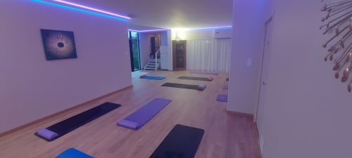 Modern yoga studio at Corse et Zen with purple lighting, exercise mats, and minimalist decor in Taglio Isolaccio