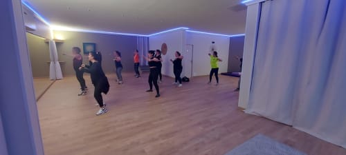 Group fitness class in modern studio at Corse et Zen hotel with blue LED lighting and wooden floors