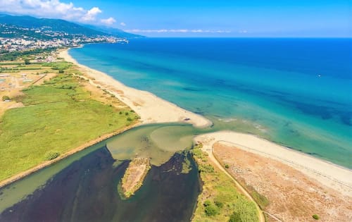 Aerial view of Corsica's turquoise coastline near Taglio Isolaccio with sandy beaches and estuary