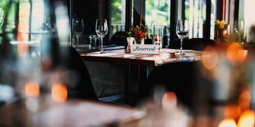 Tavolo riservato presso Villa Dom hotel a Piacenza con calici di vino e composizione floreale al centro