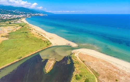 Aerial view of Taglio Isolaccio Corsica coastline with turquoise Mediterranean waters, sandy beaches and green landscape