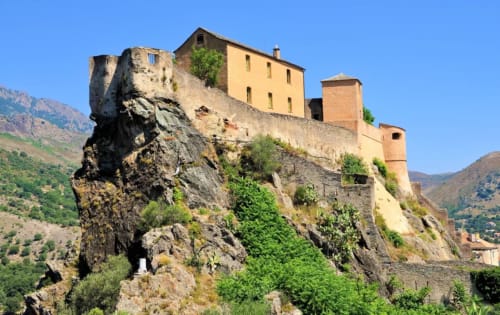 Corse et Zen cliffside hotel in Taglio Isolaccio, Corsica, perched on dramatic rocky outcrop with mountainous landscape