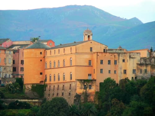Corse et Zen hotel in Taglio Isolaccio features distinctive orange and yellow architecture nestled against blue mountains