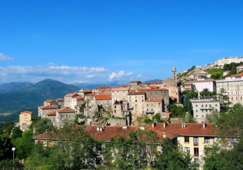 Village montagnard en Corse aux toits de terre cuite et bâtiments de pierre dominant les montagnes