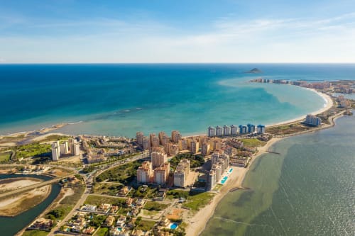 Vista aérea de la costa de Benidorm con playas de arena, aguas turquesas del Mediterráneo y modernos complejos turísticos en Blanca