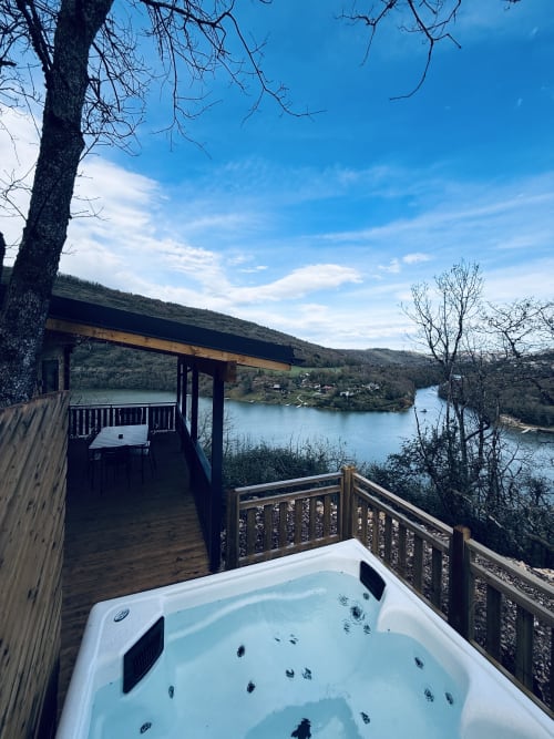 Bain à remous sur la terrasse avec vue sur le lac de la rivière Ain aux Cabanes du Belvédère à Serrières-sur-Ain, France