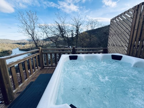 Vasca idromassaggio su terrazza in legno con vista sul fiume e le montagne presso Cabanes et lodges du Belvédère, Serrières-sur-Ain