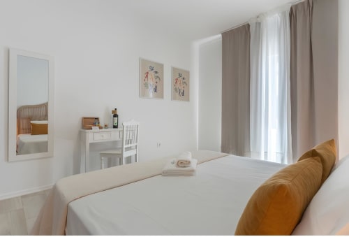 Quarto moderno na Galagana Charm House BnB em Golegã com roupa branca, acentos de madeira e cortinas elegantes