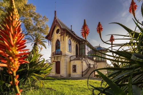 Casa de Encanto Galagana, uma villa portuguesa charmosa em Golegã com fachada amarela, flores vermelhas e arquitetura tradicional.