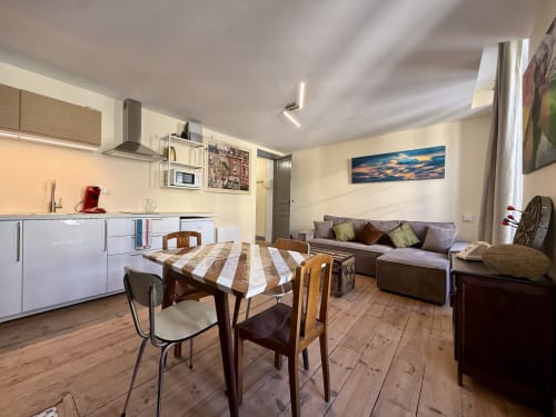 Odnowiony apartament T2 w Lourdes z otwartą kuchnią, jadalnią i salonem z sofą i dziełami sztuki