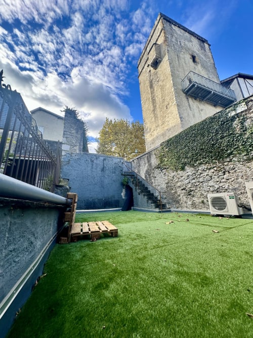 Historischer Steinhof von Ombre de la Tour in Lourdes mit grünem Rasen und efeubedeckten Mauern