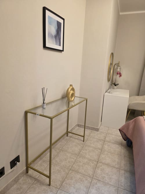 Elegante ingresso con consolle dorata, vaso decorativo e specchio in THE V Collection a Turate