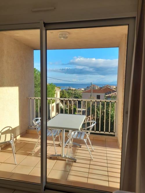 Vue du balcon de l'appartement Résidence Saint Michel à L'île Rousse avec la mer et les montagnes visibles au-delà de la balustrade