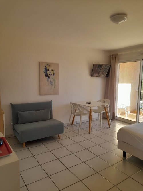 Studio moderne à la Résidence Saint Michel à L'Île Rousse avec canapé, table à manger et accès balcon