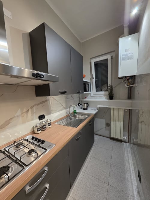 Cucina moderna nell'appartamento Manzoni 1 della THE V Collection, Turate, con piano cottura a gas, piano di lavoro in legno e acciaio inox