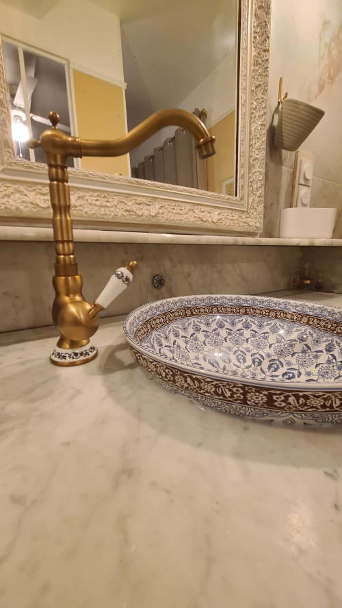 Robinet en laiton ouvragé et lavabo bleu et blanc décoratif dans la salle de bain Chambre Béziers de la maison d'hôtes Le N°9