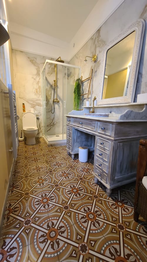 Salle de bain élégante au N°9 Chambre Béziers avec murs en marbre, carrelage à motifs, vasque miroir et douche ouverte