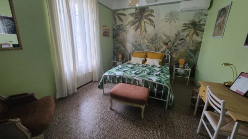 Chambre vert éclatant au N°9 d'Argeliers avec fresque tropicale, lit en métal et vue sur le jardin