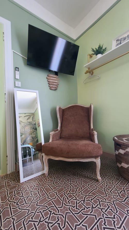 Chambre Carcassonne au N°9 B&B à Argeliers : TV murale, fauteuil cabriolet rembourré, sol à motifs