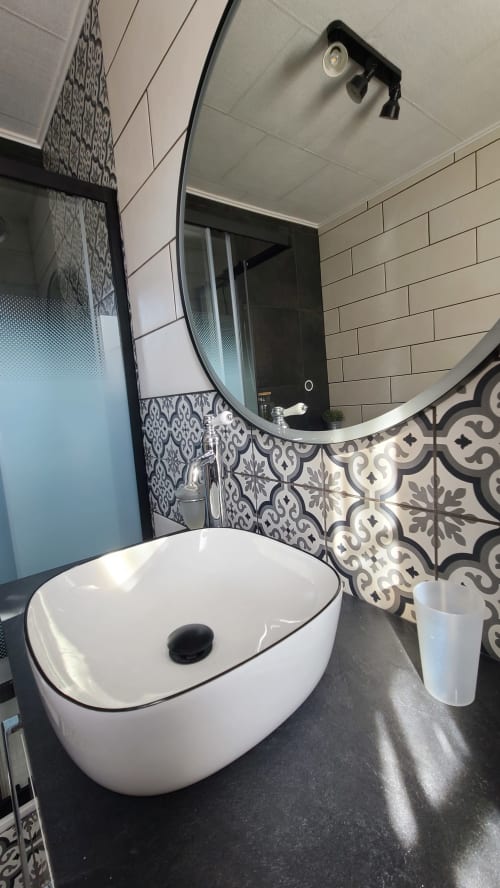 Lavabo moderne de la Chambre Narbonne au N°9 BnB à Argeliers, vasque ronde blanche et carrelage motif