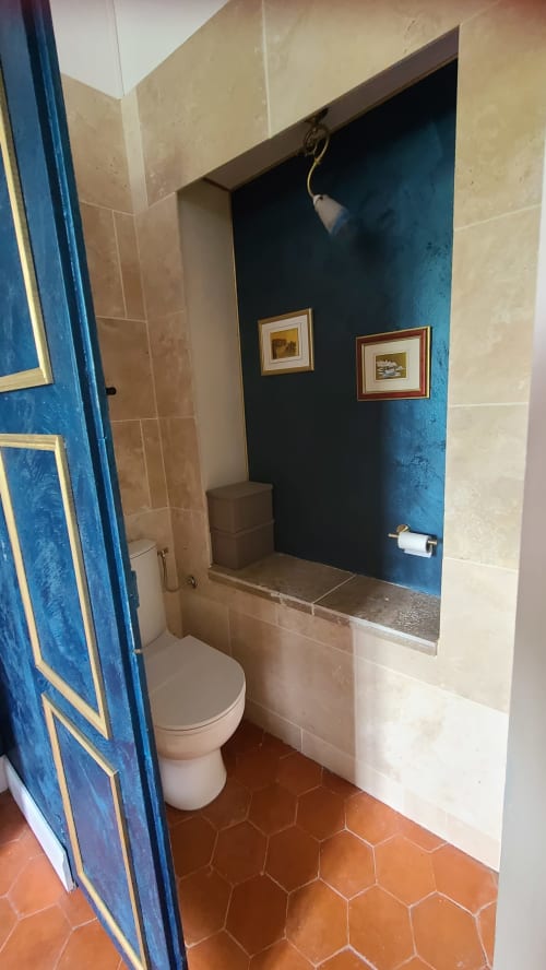 Salle de bains de la Chambre Gruissan au N°9 B&B, Argeliers, avec toilettes, niche murale bleue et carrelage en terre cuite