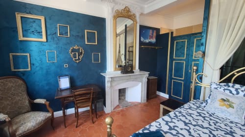 Chambre élégante au N°9 d'Argeliers avec murs bleus, cheminée et literie à motifs