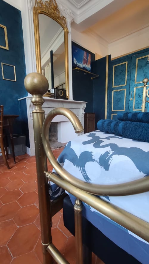 Lit doré aux courbes élégantes avec linge de lit bleu à motifs, Chambre Gruissan à la Maison d'hôtes Le N°9, Argeliers