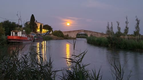 Péniche rouge et restaurant "le chat qui peche" sur le canal du midi au coucher de soleil et le pont du cantonnier, Le N°9 à Argeliers, France