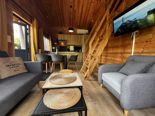 Salon cosy tout en bois avec canapé et lumière naturelle au gîte des Gîtes d’Armor à Tréguidel