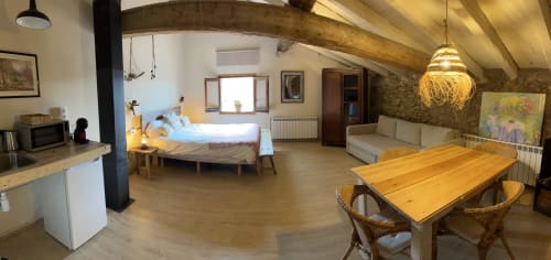 Amplia habitación estilo loft en Casa Tapiolas en Molló con cama, mesa de comedor, área de descanso y vistas a la montaña