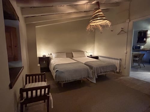 Habitación L'Isard en Casa Tapiolas en Molló, Girona con dos camas de ropa de cama rayada y vistas a las montañas