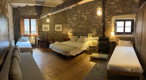 Habitación MUSSOL en Casa Tapiolas B&B en Molló, Girona con muros de piedra, suelos de madera y varias camas