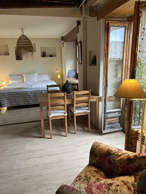 Dormitorio amplio en Casa Tapiolas de Molló con cama, zona de comedor, vista al balcón e iluminación cálida