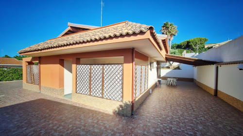 Ingresso del B&B Villa Matari con cortile piastrellato in cotto, porte a gelosia e architettura mediterranea a Fontane Bianche