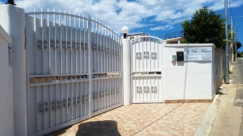 Ingresso del B&B Villa Matari con cancello e porta in metallo bianco a Fontane Bianche, Sicilia