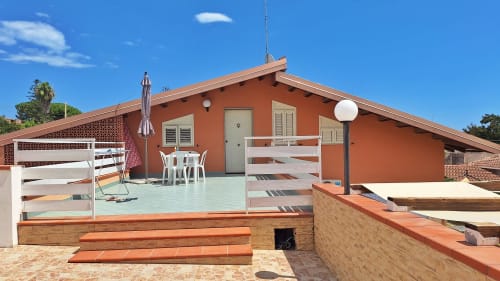 B&B Villa Matari a Fontane Bianche: casa in terracotta con terrazza azzurra, ringhiere bianche e area lounge all'aperto