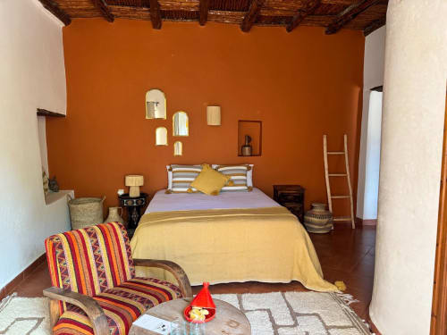Habitación étnica con encanto con techo de madera, artesanía local, alfombra bereber y objetos tejidos en el Riad Eucalyptus en Essaouira