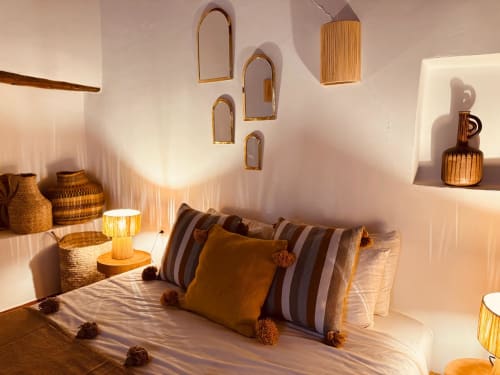 Decoración étnica con cerámica, cestas de mimbre y espejos en una habitación de un riad marroquí en Essaouira